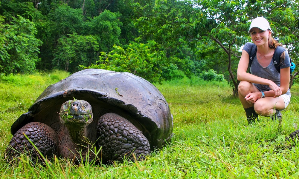 solo travel advantages - solo female traveler with galapagos tortoise